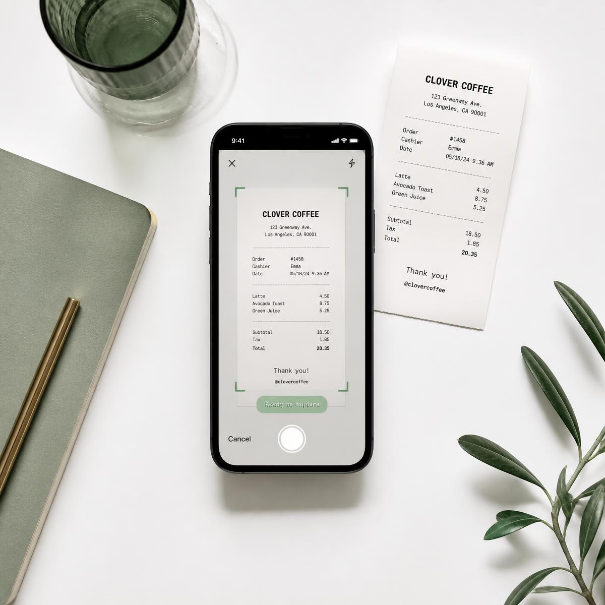 Phone scanning a paper receipt, minimalist white desk with sage notebook